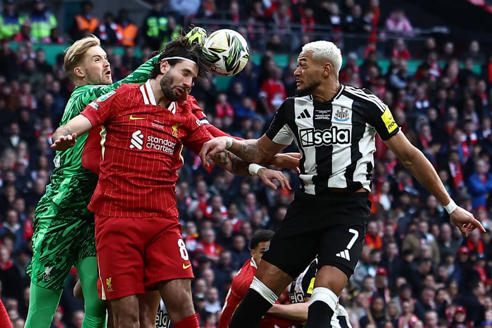 Joelinton challenges for the ball with Dominik Szoboszlai and Caoimhin Kelleher. 