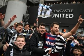 Newcastle United's fans gather beside the statue of former manager Bobby Robson ahead of an open-top bus parade by the players with the League Cup trophy through the city of Newcastle upon Tyne in north-east England on March 29, 2025, after winning the English League Cup, their first domestic trophy for 70 years. (Photo by Oli SCARFF / AFP) (Photo by OLI SCARFF/AFP via Getty Images)          