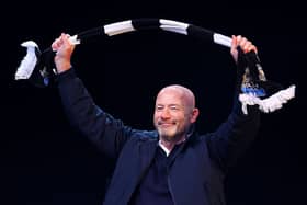 Former Newcastle United player Alan Shearer acknowledges the fans as he holds up a Newcastle United scarf while on stage during the Newcastle United trophy parade and celebration on March 29, 2025 in Newcastle upon Tyne, England. Newcastle United defeated Liverpool in the Carabao Cup Final to end their seventy-year domestic trophy drought. (Photo by Ed Sykes/Getty Images)