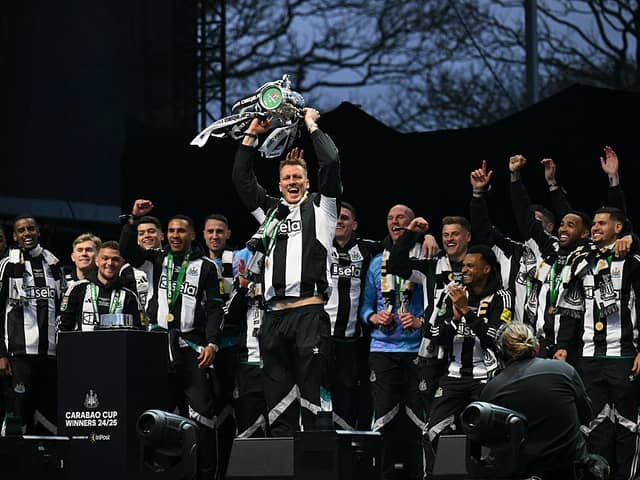 Newcastle United's English defender #33 Dan Burn celebrates with the League Cup trophy on stage at the Town Moor in Newcastle upon Tyne, in north-east England, on March 29, 2025, during a celebration and presentation with fans after Newcastle United won the English League Cup, their first domestic trophy for 70 years. (Photo by Oli SCARFF / AFP) (Photo by OLI SCARFF/AFP via Getty Images)          
