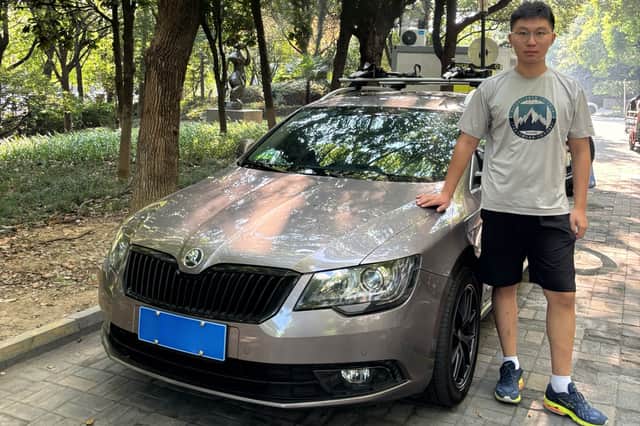 Yukun Tao alongside his car.