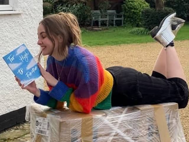 Author Charlotte Faulconbridge reading a book and smiling