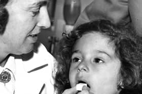 Four year old Candy Hill gets her lump of sugar with the anti vaccine on it from Nurse Spark at the Health Department in Stanhope Parade in 1965.