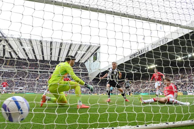 Harvey Barnes of Newcastle United shoots to score the second goal past goalkeeper Altay Bayindir of Manchester United during the Premier League match between Newcastle United FC and Manchester United FC at St James' Park on April 13, 2025 in Newcastle upon Tyne, England.