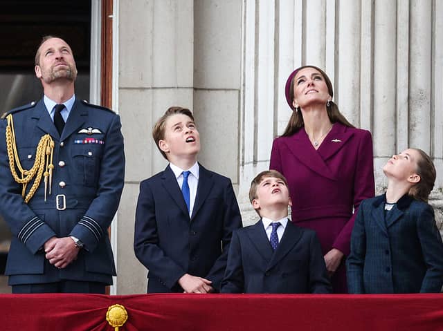 Prince William, Prince of Wales, Prince George of Wales, Prince Louis of Wales, Catherine, Princess of Wales and Princess Charlotte of Wales watch the Red Arrows flypast from Buckingham Palace.