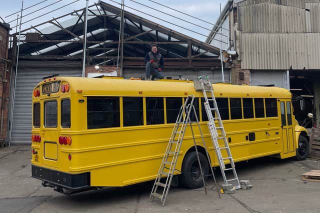 Ty Burns works on the American school bus the couple have converted for their family travels in Europe