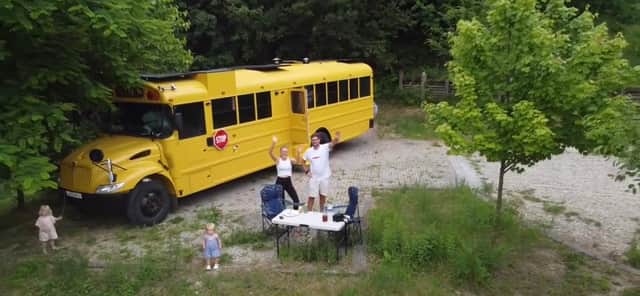 Lotti Harrison and Ty Burns with their American school bus that they are travelling around Europe in with their toddlers