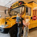 Lotti Harrison and Ty Burns with their American school bus that they are travelling around Europe in with their toddlers