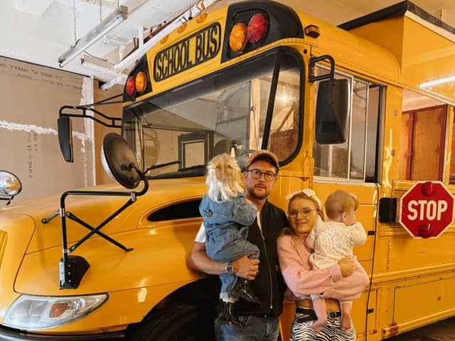 Lotti Harrison and Ty Burns with their American school bus that they are travelling around Europe in with their toddlers