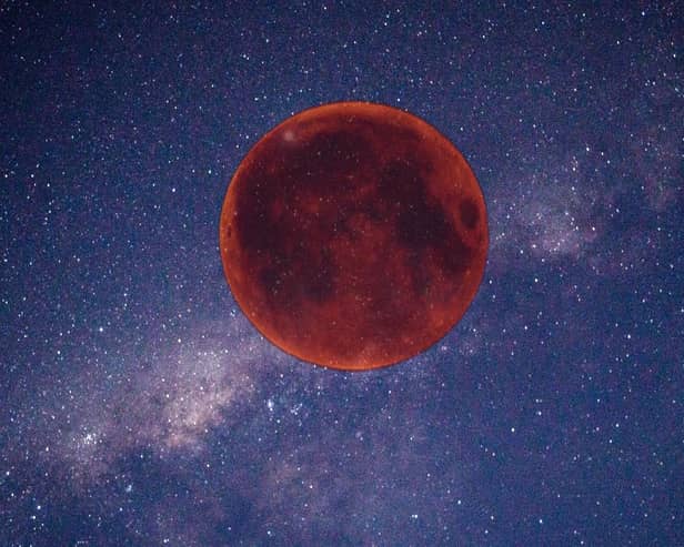 Digitally created image of a red Moon in the night sky.