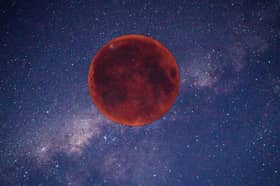 Digitally created image of a red Moon in the night sky.