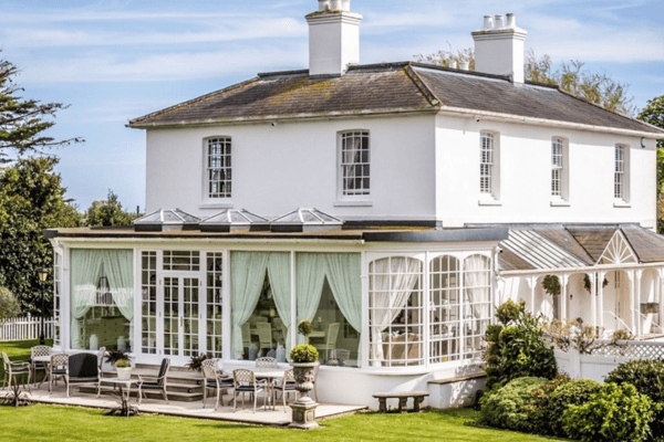 Merston House blends timeless Regency architecture with modern country living, complete with an orangery and sun-soaked patio for entertaining.