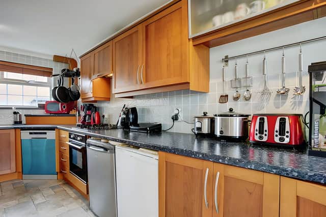 A spacious kitchen with a breakfast bar provides a practical hub for everything from busy mornings to relaxed family meals.