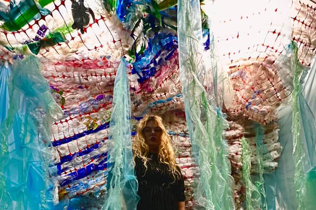 Jessica Leigh with the wave of plastic from the What Lies Beneath exhibition.