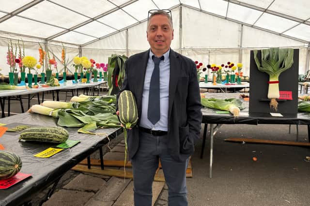 Faisal Ali, one of the organisers of the Monkton Leek, Vegetable and Flower Show, holding one of his entries.