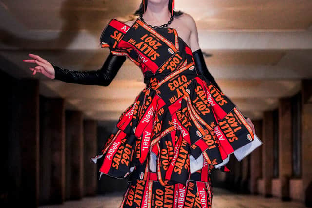 The dress is made of running bib numbers.
