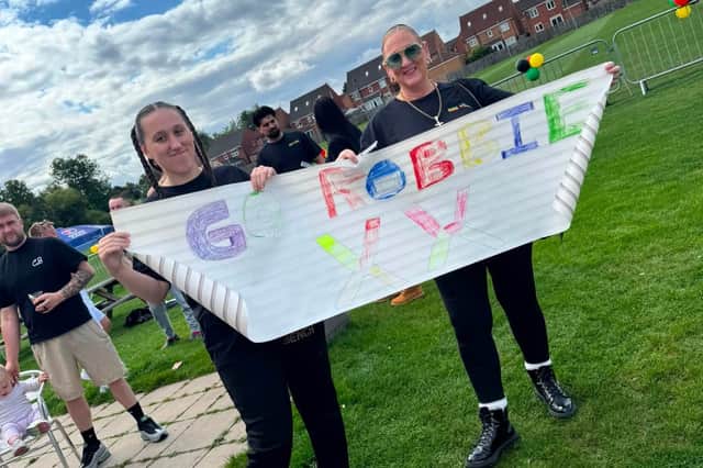 Robbie's cousin Madison Gallagher and aunty Mandy Gallagher roll out the welcoming banner