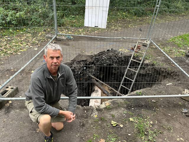 Campaigner Dave Green next to the hole dug to repair the pipe.
