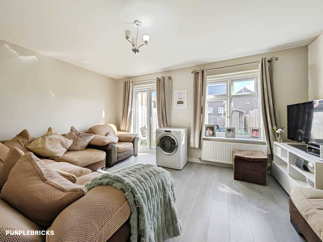 The ground-floor living room provides a separate place to unwind, with direct access through to the enclosed rear garden.