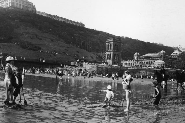 1913: Children paddling on the beach at Scarborough in Yorkshire.