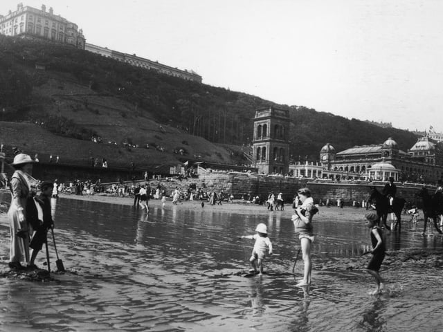 1913: Children paddling on the beach at Scarborough in Yorkshire.