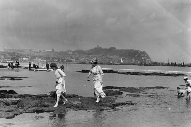 circa 1910: Bathers in the South Bay at Scarborough, a popular coastal resort in North Yorkshire. The 12th century castle stands on the cliff in the background.