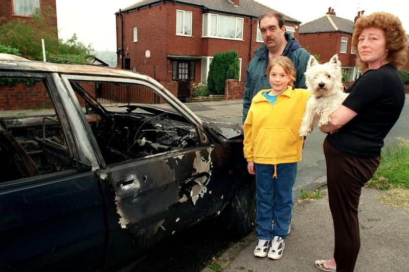 A Bramley family was left shellshocked after a burnt out car was pushed down their drive in Calverley Gardens. Pictured is Paul Davison with wife Carol, daughter Katie and pet dog Sam.