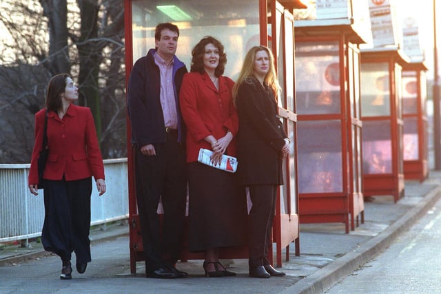 Members of the Tall Club, from left, Neil Summers, Belinda Davy and Deborah Leng at a Leeds bus stop are noticed by a passer-by.
