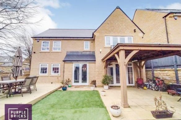 The rear garden has a large decked terrace, a patio from the house and a wooden gazebo, and artificial turf.