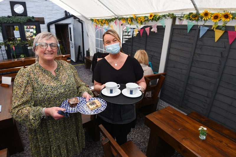 Nicola Burns (left) and Angela Gallacher serving drinks and sweet treats in their outside area at Time coffee shop, Preston Road, Standish.