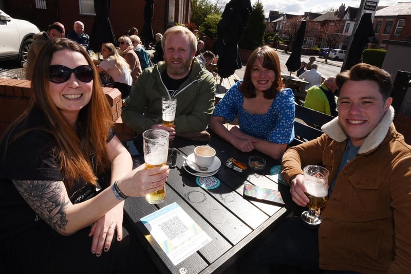 Cheers! Wiganers enjoy a pint in the sun in the outside area of Sherringtons, Wigan.