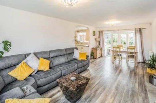 Large through lounge with dining area, offering feature fire place with log burner, laminated flooring, double glazed window and patio doors leading the large rear garden.
