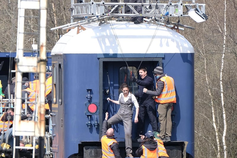 Tom Cruise checks the safety rigging of his co-star.