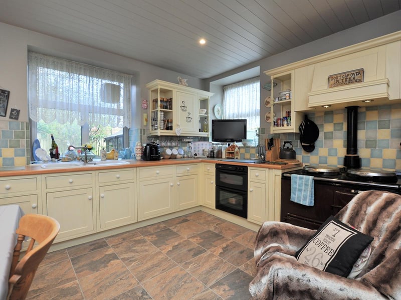 The welcoming kitchen includes an Aga and cream units