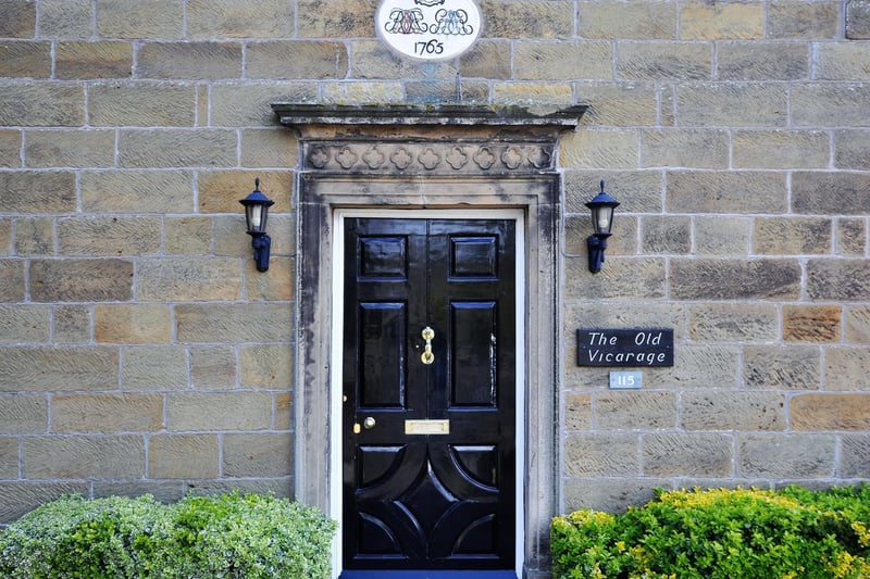 The door to The Old Vicarage with plaque above that lists its age