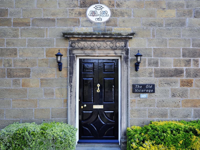 The door to The Old Vicarage with plaque above that lists its age