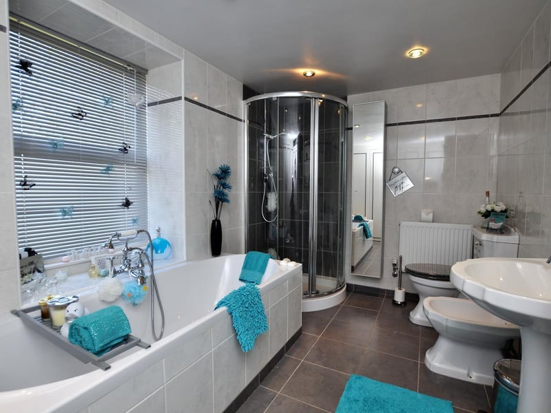 White suite within this modern bathroom that also has a shower cubicle