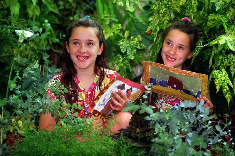 Identical twins Laura (left) and Jade Smurthwaite among a rainforest display of plants and flowers in their class room at Primrose Hill School.
