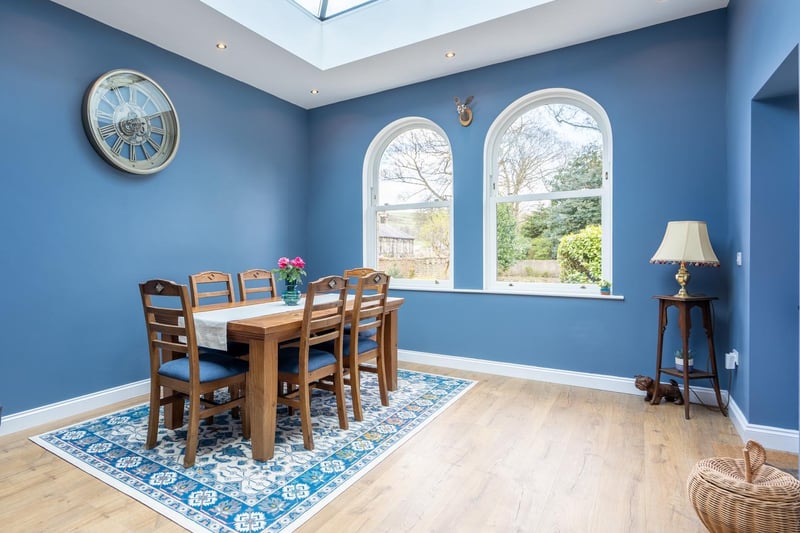 This dining room features blue walls and large, arched windows