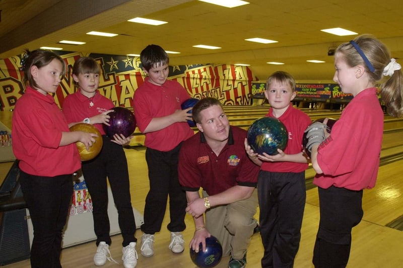Ten-pin bowling champion Tim Mack visits LA Bowl. He is pictured teaching members of The Young Bowlers Club