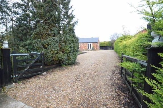 The large driveway which stretches from the entrance gates all the way round to the back of the property