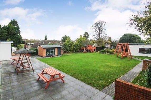 The rear garden is a huge plot with a large patio area, a fish pond and two outbuildings