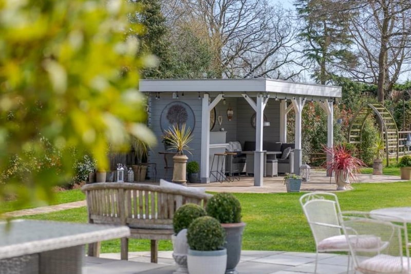 The garden features a summer house and outdoor kitchen complete with bar and television