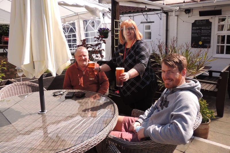 Hamish McConchie and Thomas Wright being served by Claire Woodward at the Three Kings Inn, Threekingham. Hamish said the last time he visited a pub was last summer and had been looking forward to his pint. EMN-210413-153730001