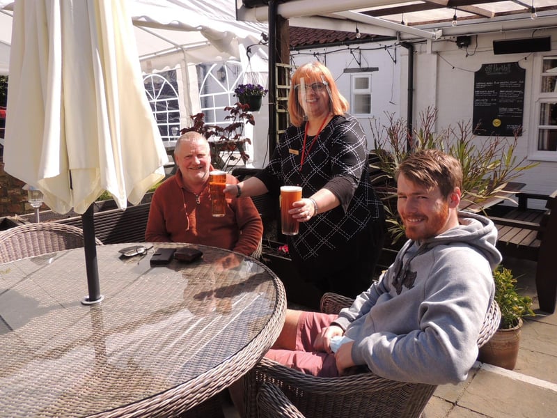 Hamish McConchie and Thomas Wright being served by Claire Woodward at the Three Kings Inn, Threekingham. Hamish said the last time he visited a pub was last summer and had been looking forward to his pint. EMN-210413-153730001