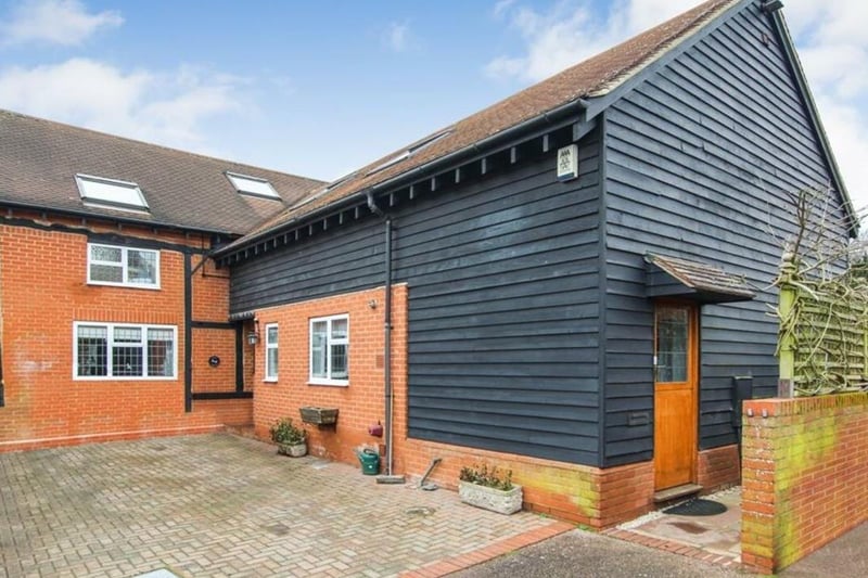 This stylish dark wood cladding breaks up the home's brick exterior