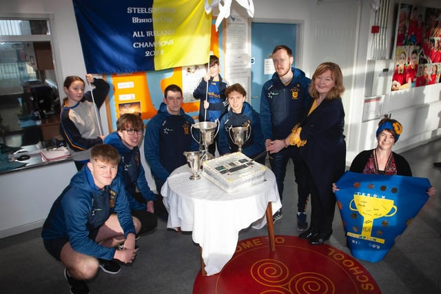 Cutting the celebration cake baked by McDaid's Bakery are, from left, Oran, Cahir, Eoghan, Donncha, Neil, Mrs Siobhan Gillen, Prinipal, Mrs O'Doherty, Mrs Gilmore and pupils Leo and Georgia holding the banner.