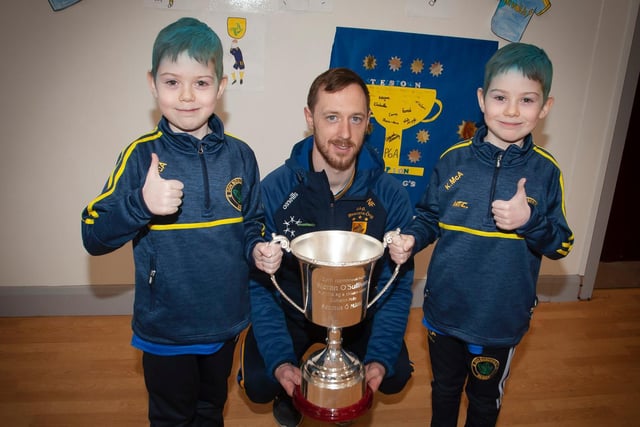 Twin brothers, Shane and Kayden, dressed in blue and yellow to mark this very special occasion with Steelstown captain, Neil Forrester and the Kieran O'Sullivan Cup. (Photo: Jim McCafferty)
