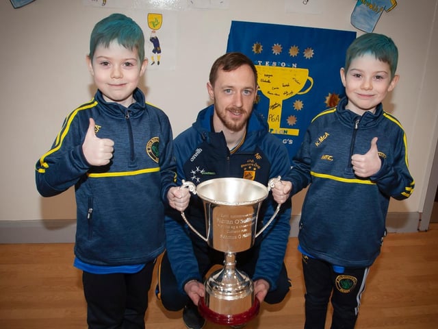 Twin brothers, Shane and Kayden, dressed in blue and yellow to mark this very special occasion with Steelstown captain, Neil Forrester and the Kieran O'Sullivan Cup. (Photo: Jim McCafferty)