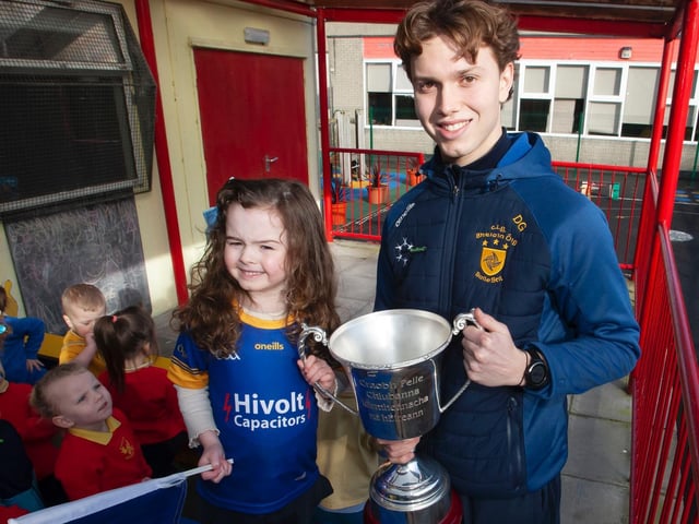 Former pupil and Steelstown player Donncha Gilmore and nursery student, Rosie, delighted to hold the Kieran O'Sullivan Cup together during the Brian Ogs visit to the school recently. (Photo: JIm McCafferty)